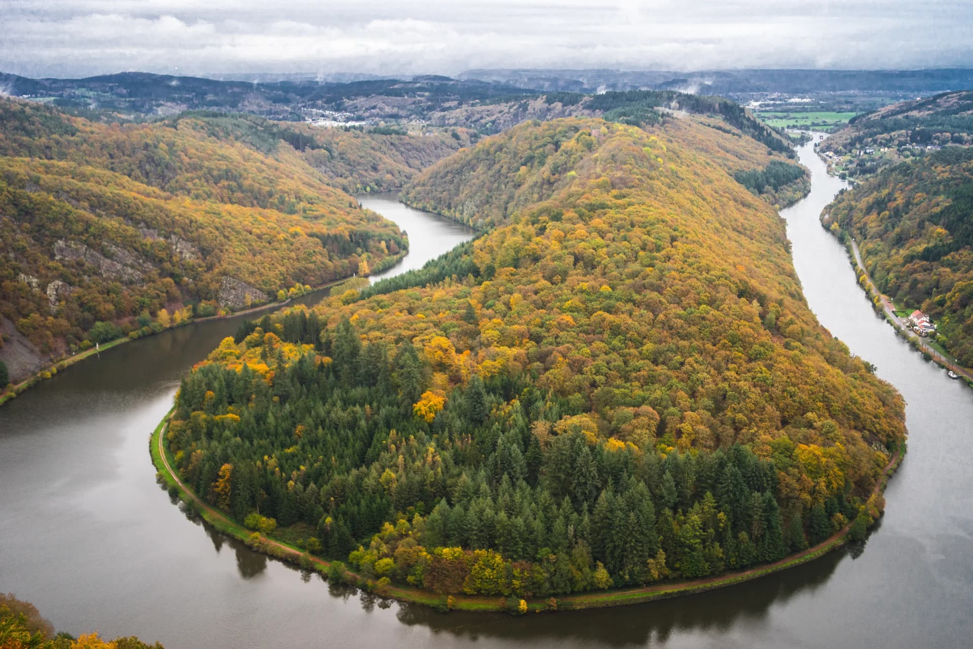 Die Saarschleife bei Mettlach im Herbst, von oben gesehen, mit bewaldeten Hängen in der Großregion