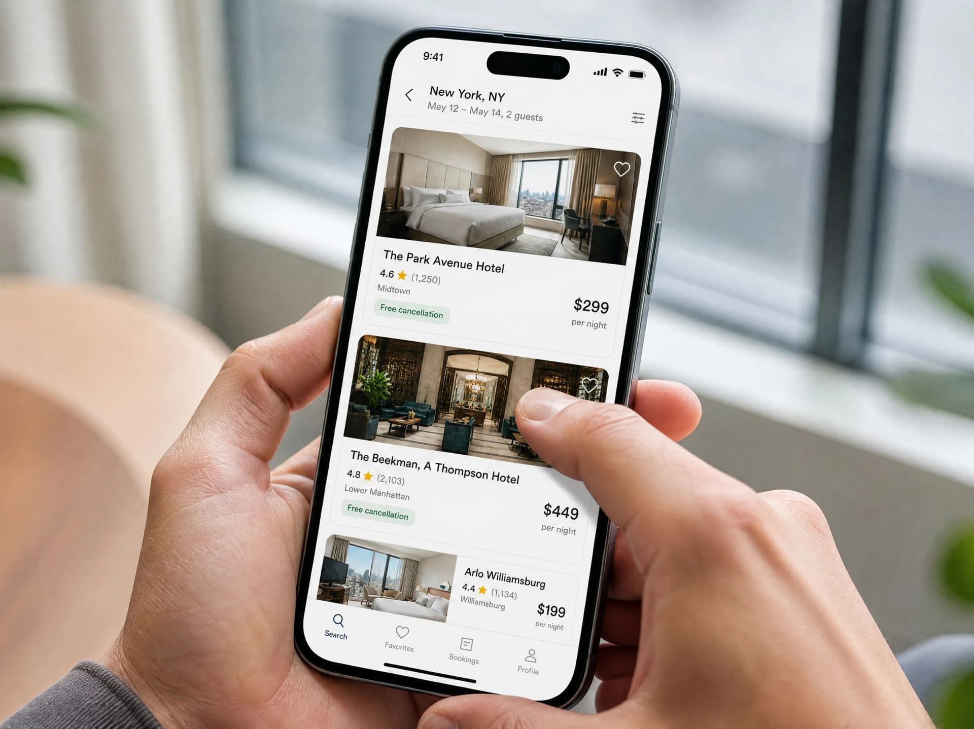 Jemand scrollt auf dem Handy durch Buchungsangebote für Hotels