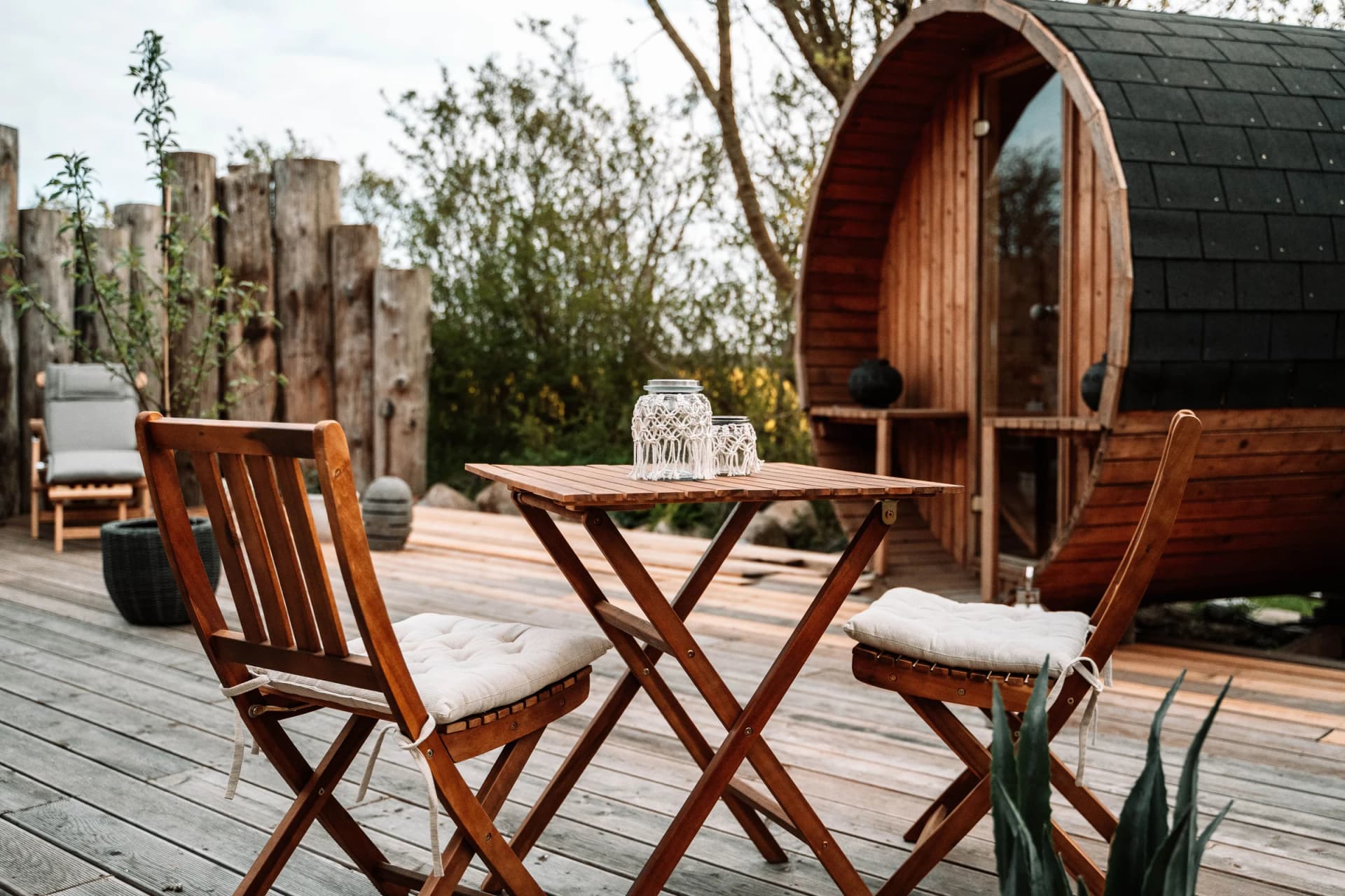 Außensauna im Holzfass-Stil mit Terrasse und Holzdielen im Garten von Henkieker