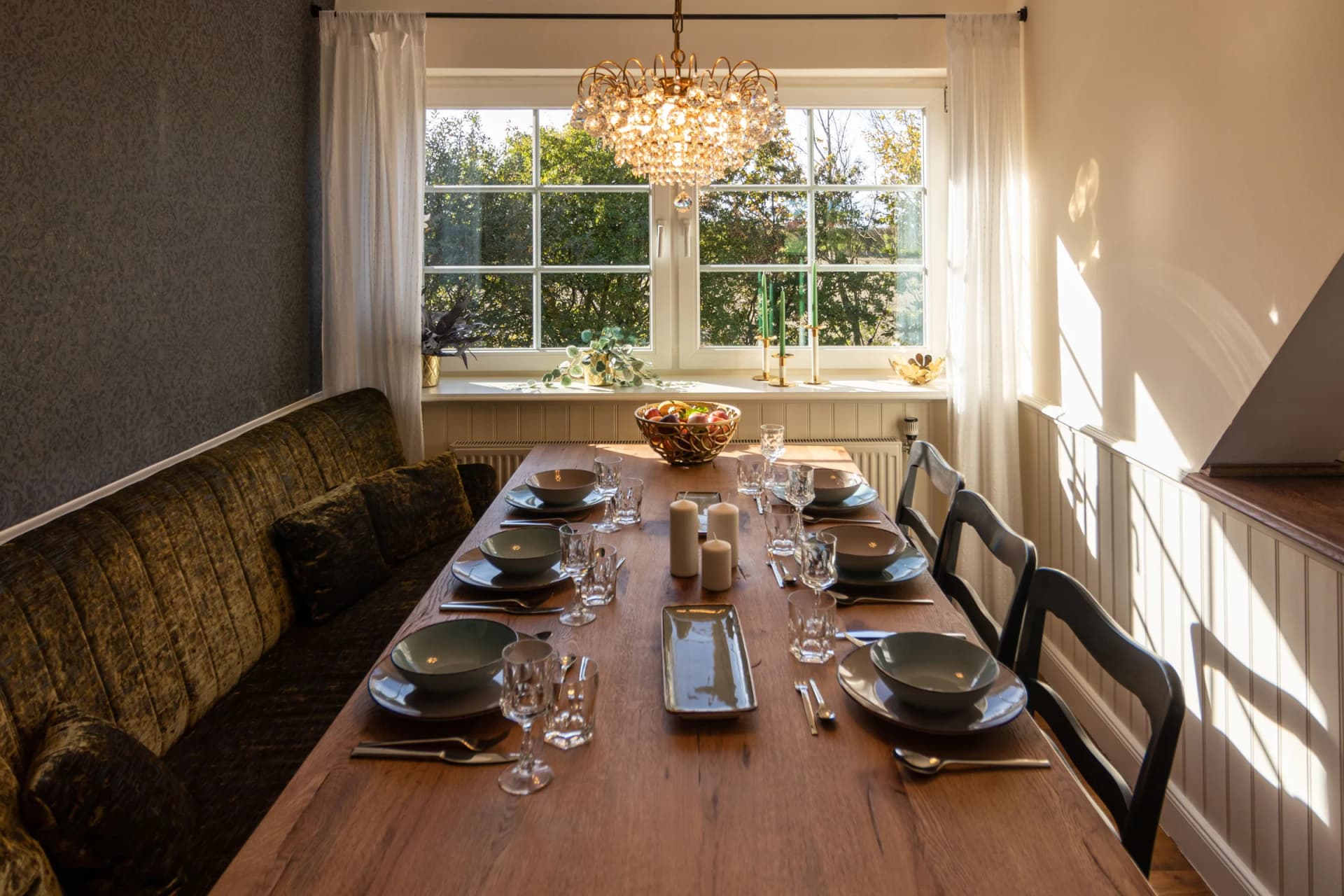 Esszimmer von Henkieker mit Kronleuchter, dunklen Wänden und großem gedeckten Tisch
