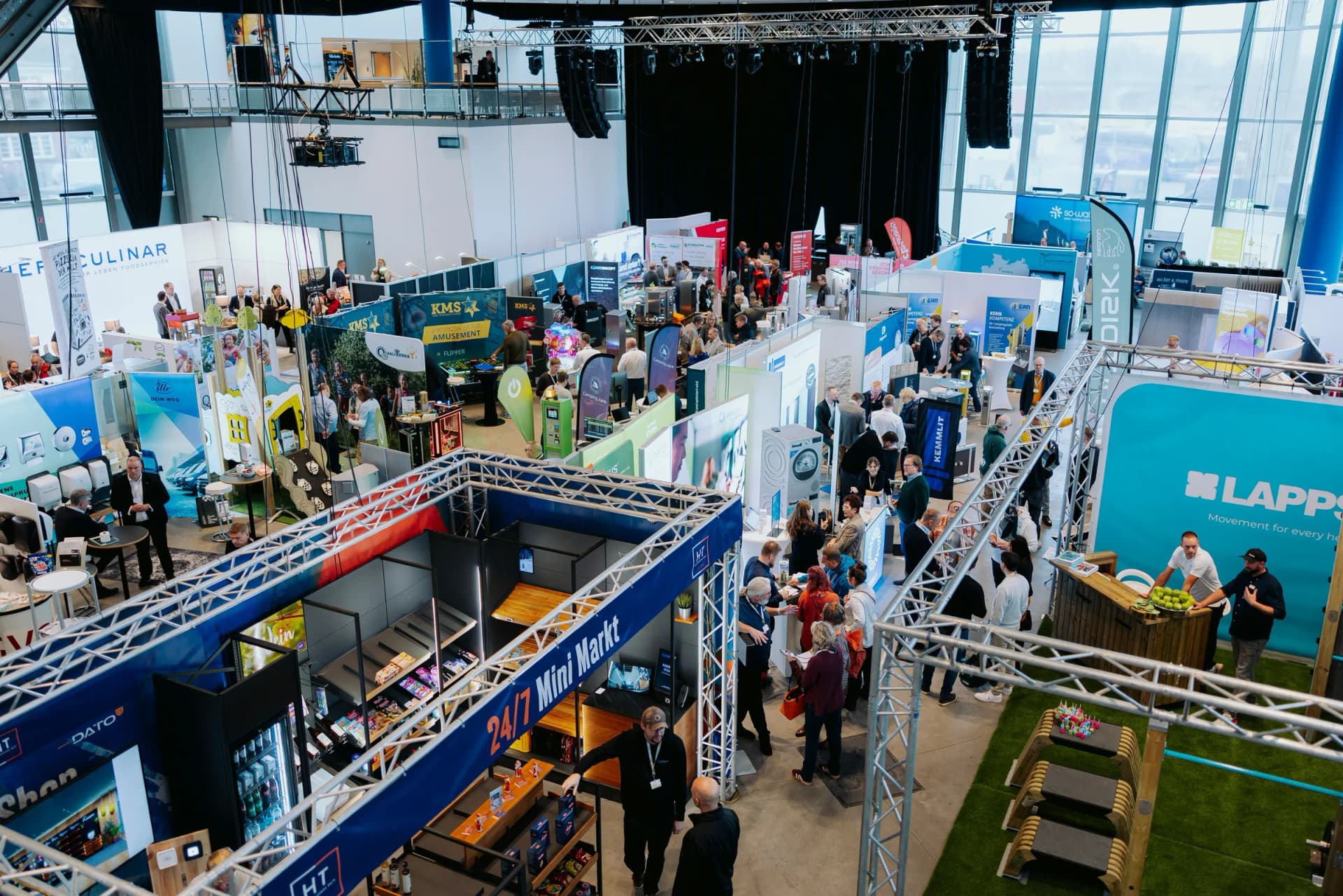 Top-Down-Blick auf die Messehalle des NCT mit Ständen, Ausstellern und Besuchern