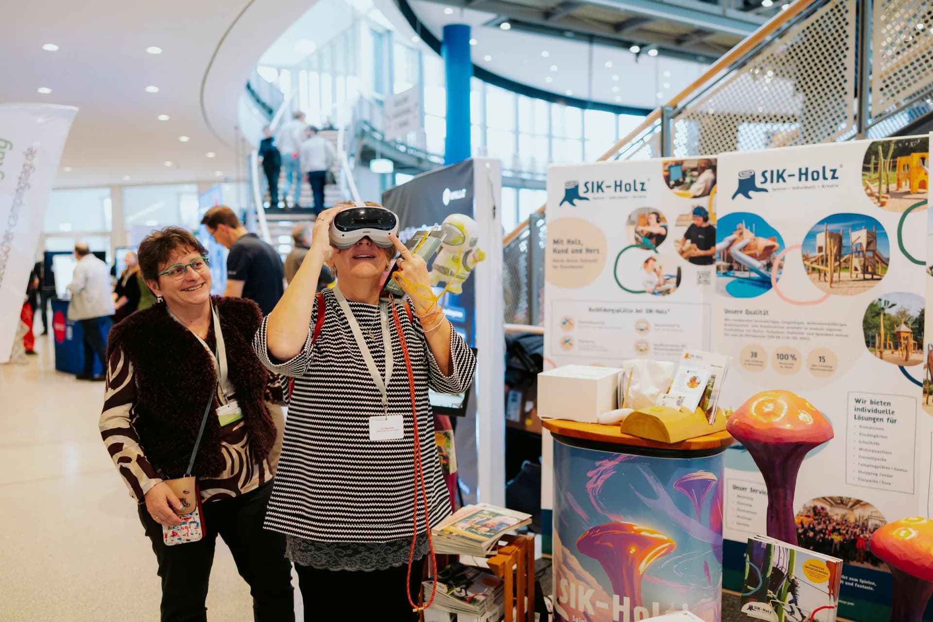 Besucherinnen testen VR-Brillen am Stand von SIK-Holz auf dem NCT